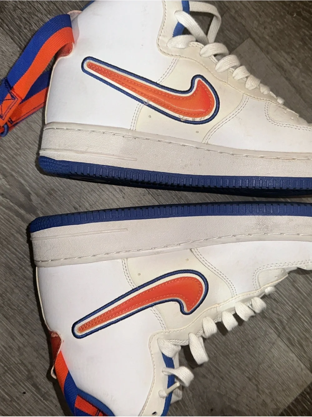 Nike White High-Top Sneakers with Orange Swoosh and Blue Accents